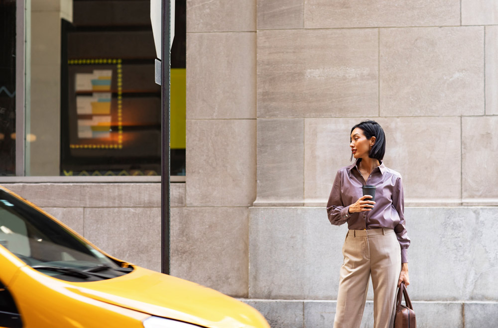 Professional woman standing at an urban crosswalk, embodying confidence and sophistication